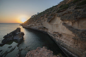 Beautiful view of sunset on a cliff by the sea and a clay wall in El Toro, Mallorca, Spain