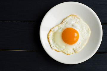 Fried chicken egg on a white plate. View from above