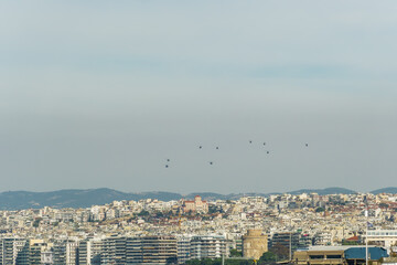 Military helicopters flying above a city. Greek Air Force AH-64 Apache, Kiowa Warrior & Huey UH-1H on formation in Thessaloniki at October 28 commemorating Hellenic no against Italian 1940 ultimatum.
