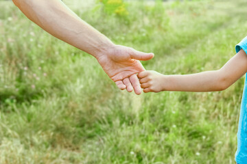 hands of parent and child in nature