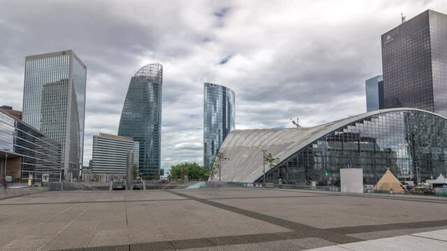 Skyscrapers of Defense timelapse hyperlapse modern business and financial district in Paris with highrise buildings and convention center. View from square near Grande Arche. Blue cloudy sky in summer
