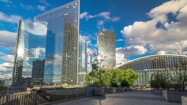 Skyscrapers of Defense timelapse hyperlapse modern business and financial district in Paris with highrise buildings and convention center. View from bridge. Blue cloudy sky in summer day. Reflections