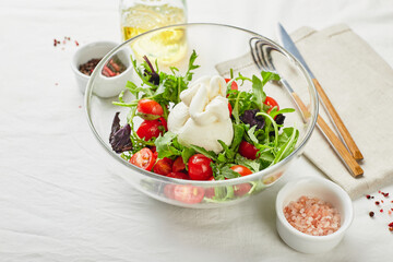 Burrata, Italian fresh cheese made from cream and buffalo or cow milk, with tomato, arugula and red basil salad