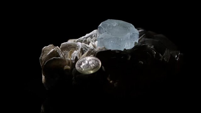 An aquamarine crystal in a matrix of muscovite, beautiful color and clarity, 4k close up.