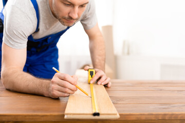 Carpenter In Coverall Working Measuring Wooden Board Making Furniture Indoors