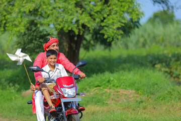 Young indian farmer dropping his child to school.