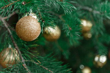 Decoration of Christmas tree with hanging golden yellow ball