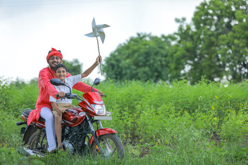 Young indian farmer dropping his child to school.