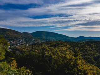 Mountains of the North Caucasus on an autumn day under a cloudy blue sky.