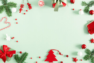 Christmas modern composition. keyboard, gift, fir branches, red berries, Xmas decorations on light green background. Christmas, New Year, winter concept. Flat lay, top view, copy space