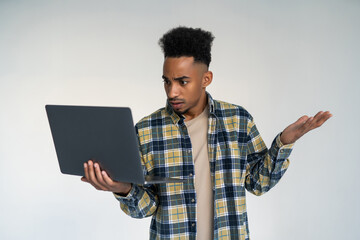 Young african american businessman using laptop standing over isolated white background stressed with hand on head, shocked with shame and surprise face, angry and frustrated.