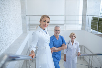 Obraz premium Group of smiling doctors standing on hospital stairs