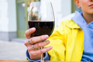 Red Georgian wine in the wineglass, alcoholic drink and woman hand