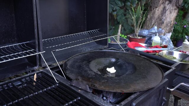 Static shot of lard being poured into a hot traditional comal for making chalupas in Puebla, Mexico