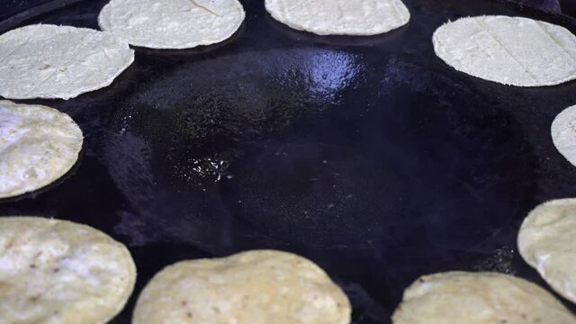 Close up shot of tortillas being fried in pork fat to make chalupas