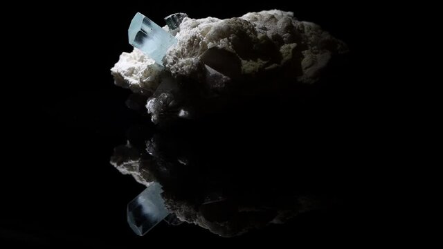 A single very clear crystal of aquamarine emerges from a feldspar matrix. Sample from Argentina.