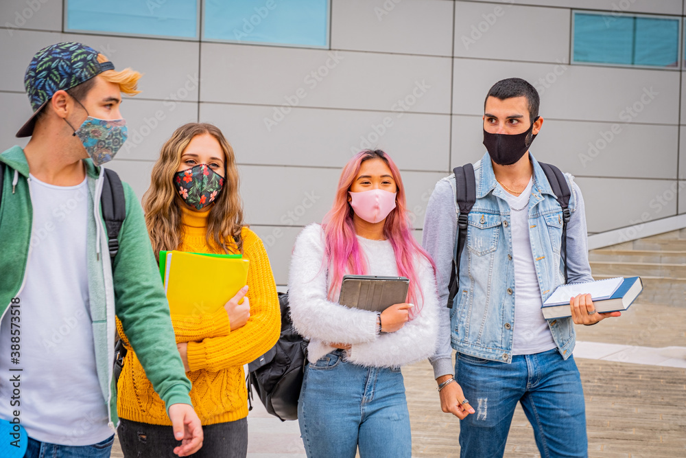 Wall mural Group of young teenagers arguing and walking around the street with protective mask in pandemic covid 19 period