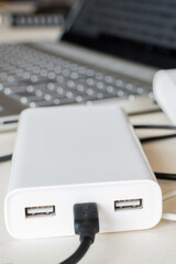 Power bank charges on desk. Universal external batter