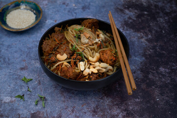 Vegan noodles and plant based meat  stir fry on gray table, copy space