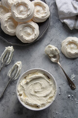 Cooking meringues Pavlova cakes from egg whites and sugar. Abstract food background, copy space. Top view.