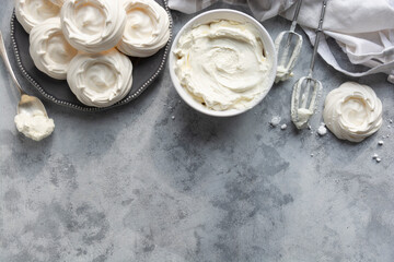 Cooking meringues Pavlova cakes from egg whites and sugar. Abstract food background, copy space. Top view.