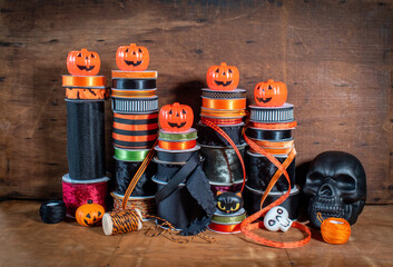 Stack of Halloween craft ribbon spools in orange and blacks