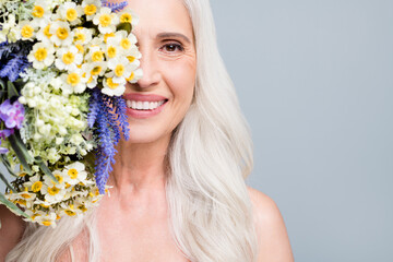 Closeup photo of beautiful retired woman hide half face big bunch wild flowers coquettish isolated...