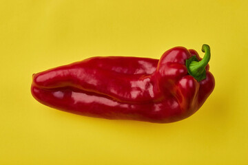 Red pepper of an unusual shape on a yellow background