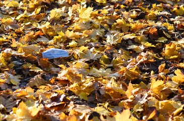 Waste during COVID-19. Used Medical face mask on the floor. Disposable Face Mask contaminating a nature. Environmental concern concept. Czech republic, Europe.