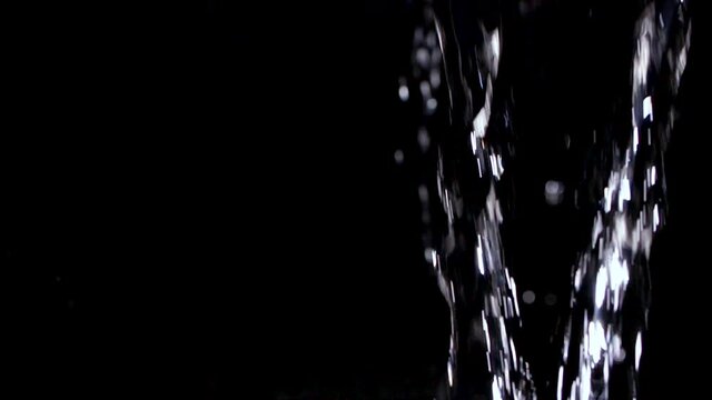 Stream of Clear Water pouring into black background in slow motion 240p