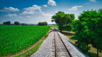 Fototapeta na wymiar Old Rail Road Track going Thru Countryside on a Sunny Day