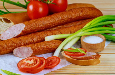 Chives, tomatoes and kielbasa on wooden background.