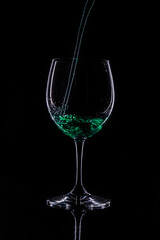 
cup with green drink. serving drink. serving cup with black background.