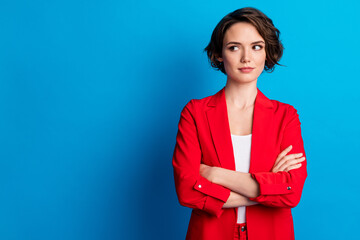 Portrait of attractive brown-haired lady folded arms looking aside copy space isolated over bright...