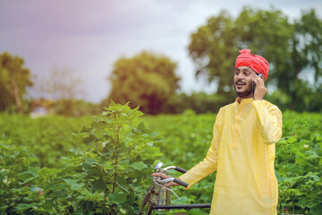 Young indian farmer or labor talking on mobile phone