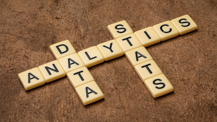 analytics, data and stats crossword in ivory letter tiles against textured handmade paper, discovery, interpretation, and communication of meaningful patterns in data