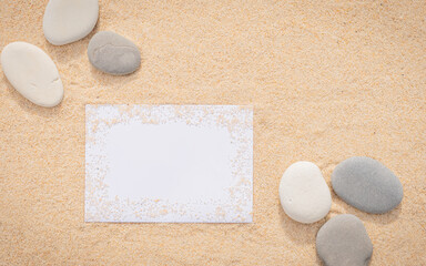 Fototapeta na wymiar Arrière-plan grains de sable de mer, sable fin de plage avec enveloppe et galets. Emplacement pour texte sur papier. 