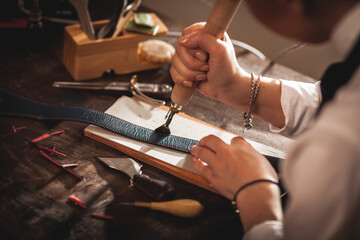 Leather handbag craftsman at work in a vintage workshop. Small business concept