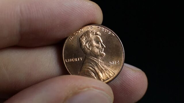 American cent shining in man hand, close up footage. Macro coins. 
