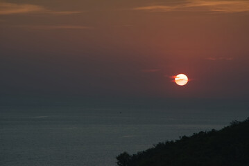 Growing red cloud over blue sea in sunset time