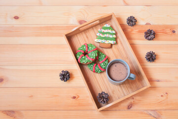 Christmas gingerbread cookies and mug of homemade hot chocolate on tray on wooden table. Top view, copy space.