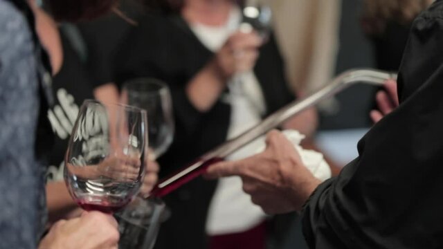 Pouring wine sample from a barrel into a wine glass