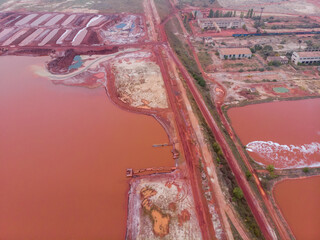 Aerial Bird eye Top View at Red Clay Pools With a Gateway Sluices Seethes: Spillway of a Clay Factory