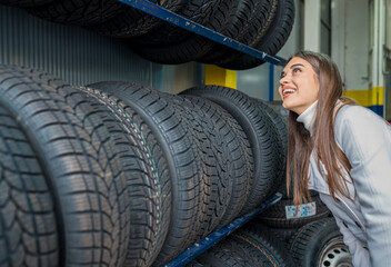 Obraz na płótnie Canvas A female choosing tires in the garage
