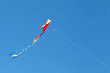 kite on the blue sky in sunny weather and wind. Kite flying in summer with copy space. Liberty.