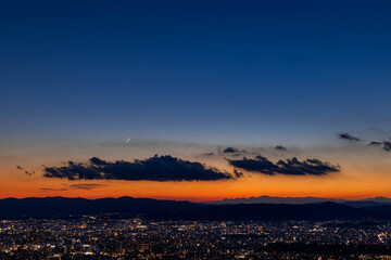 Evening Glow, Crescent Moon, and the City