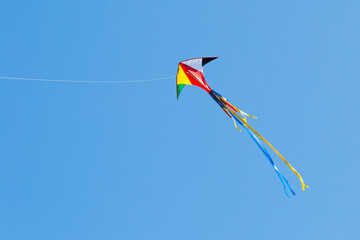 kite on the blue sky in sunny weather and wind. Kite flying in summer with copy space. Liberty.