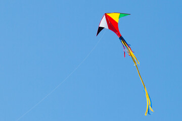 kite on the blue sky in sunny weather and wind. Kite flying in summer with copy space. Liberty.