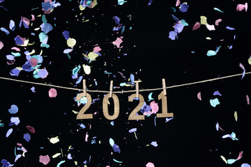 Año nuevo de 2021 en números de madera dorada colgados de una cuerda con pinzas de oficina sobre...