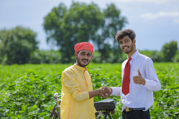 indian farmer and banker standing at field